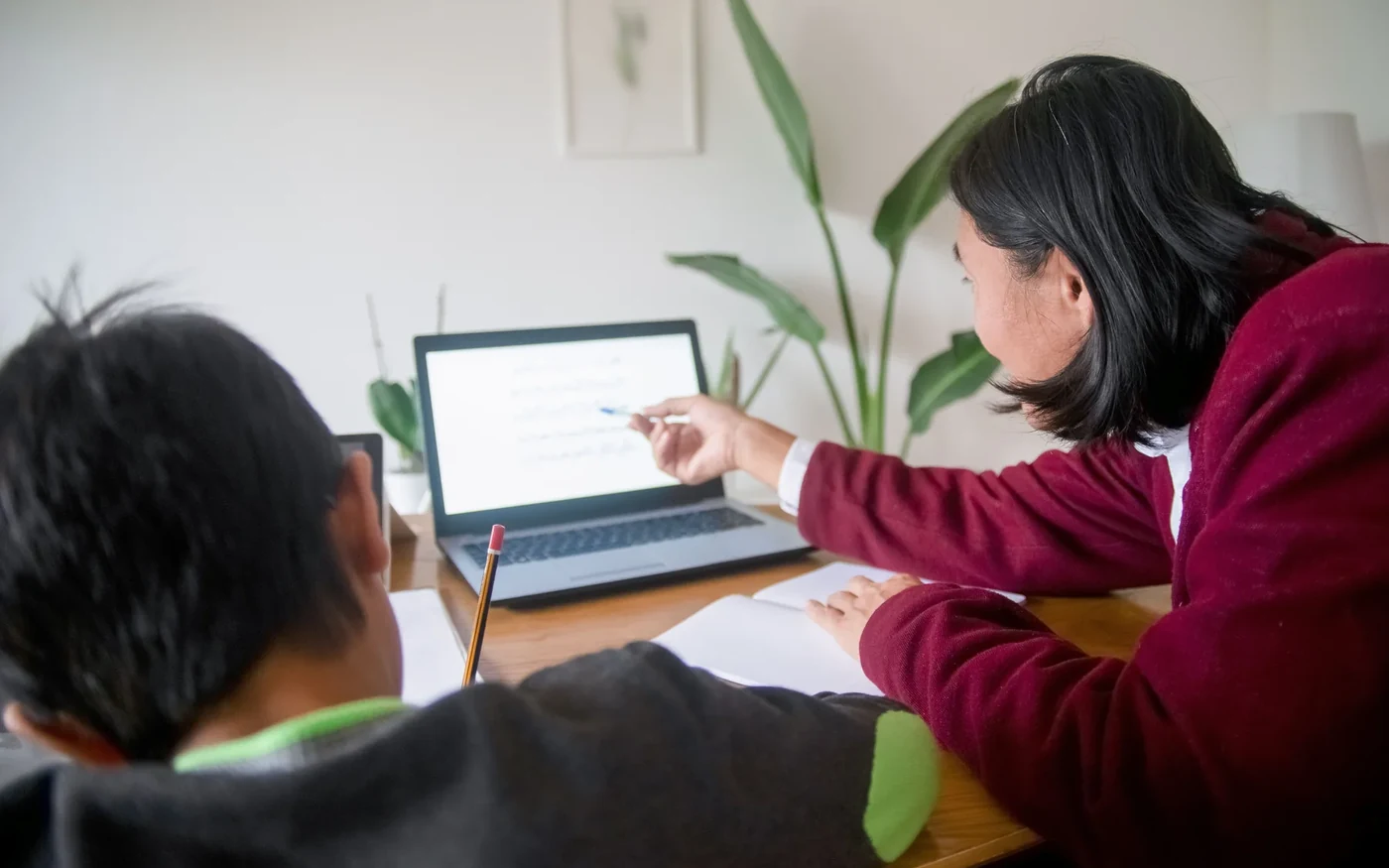 An adult reviewing a learner’s digital progress on a laptop