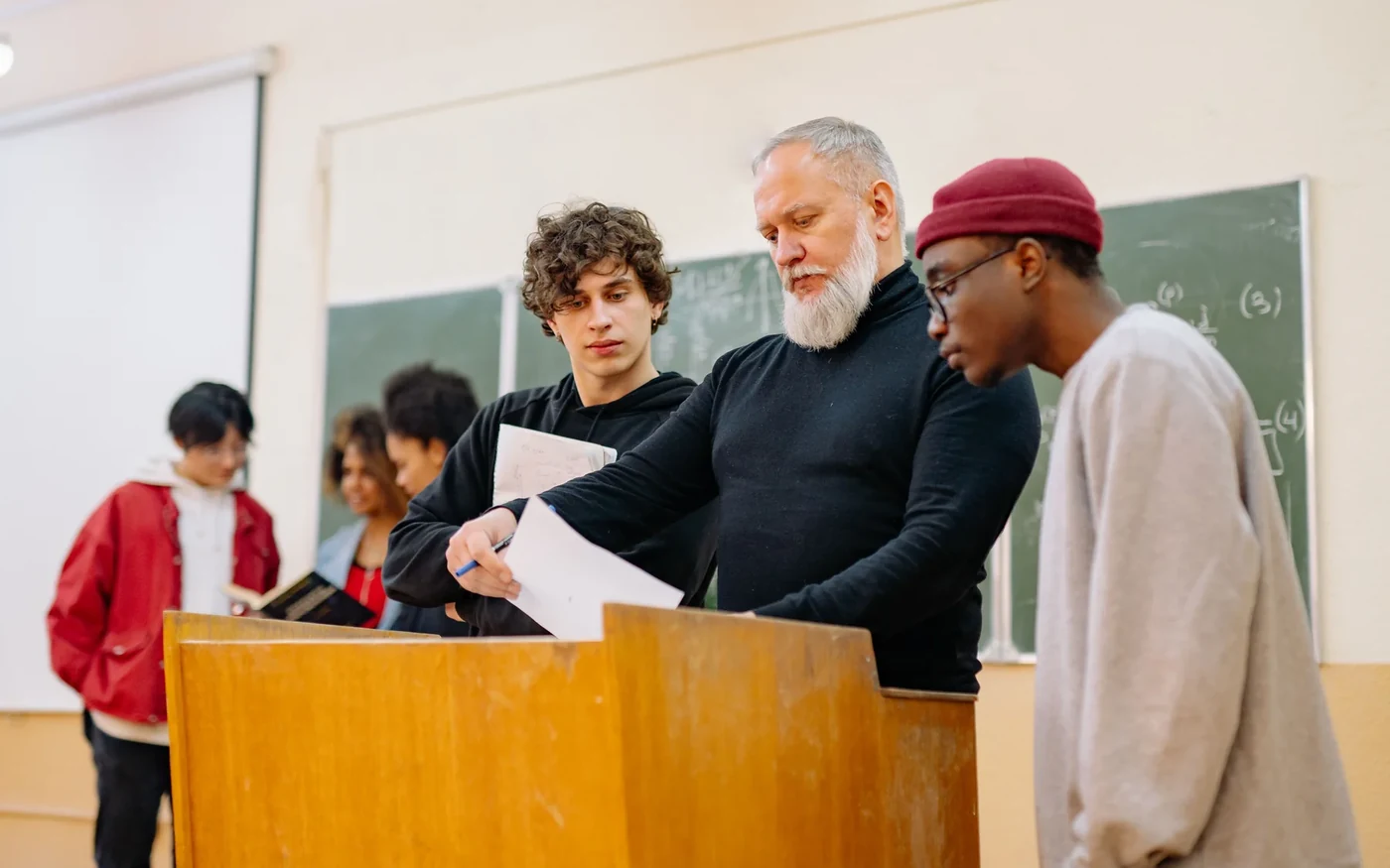 An educator and learners reviewing work as a group